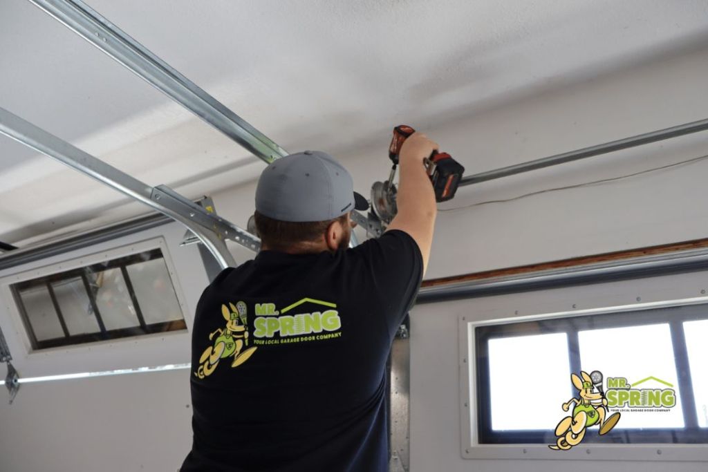 Technician performing a garage door drum replacement