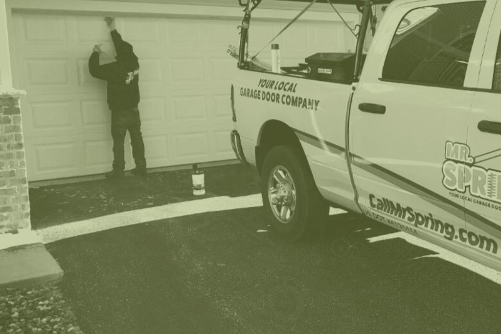 Technician performing maintenance on garage door