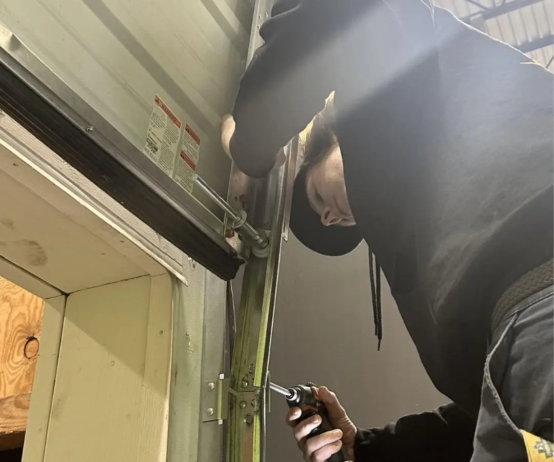 Technician repairing a garage door