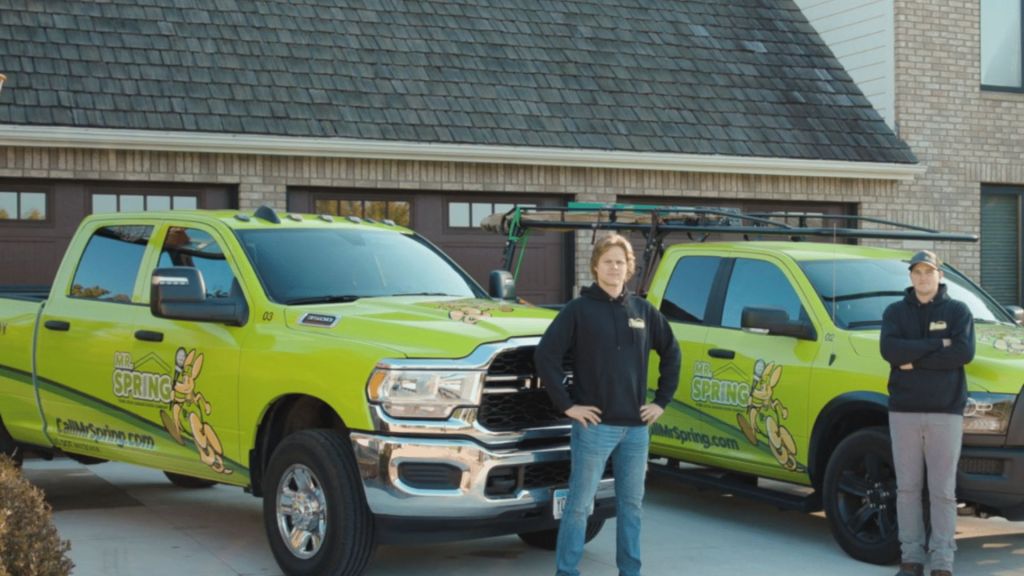 Mr. Spring employees standing in front of their work trucks