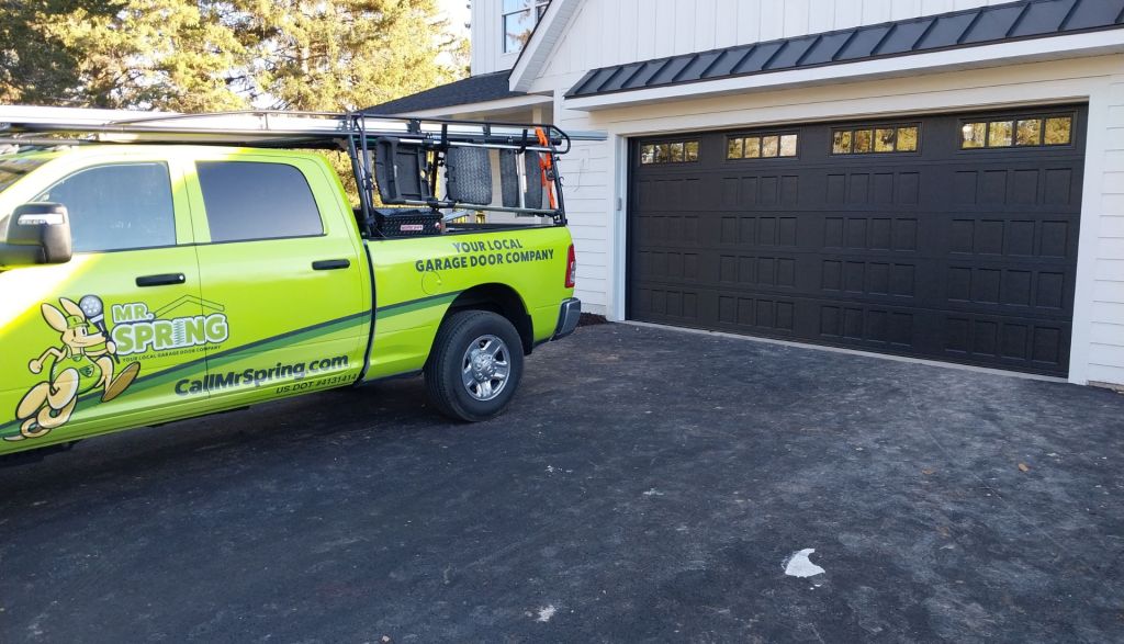 bright green Mr. Spring pickup sits in front of a new garage door