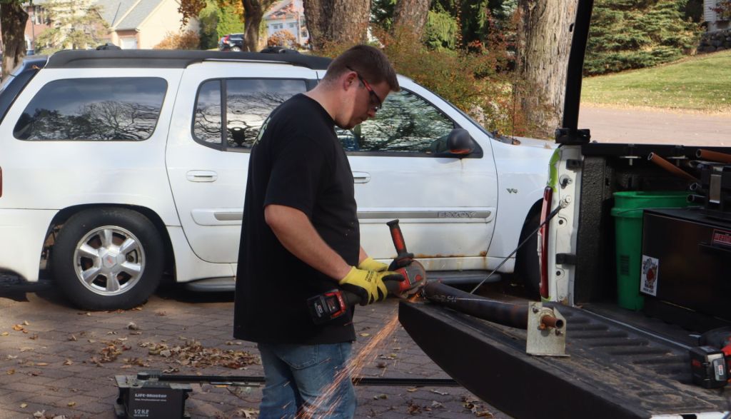 garage door technician applying a power saw to a garage door spring