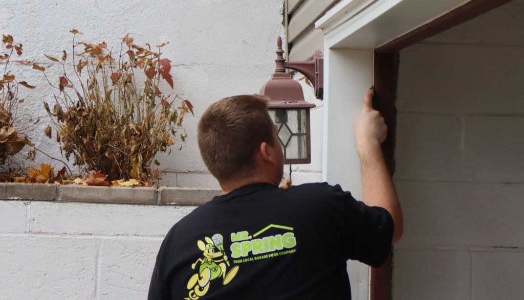 Mr. Spring technician uses tool to smooth sealer on a new garage door