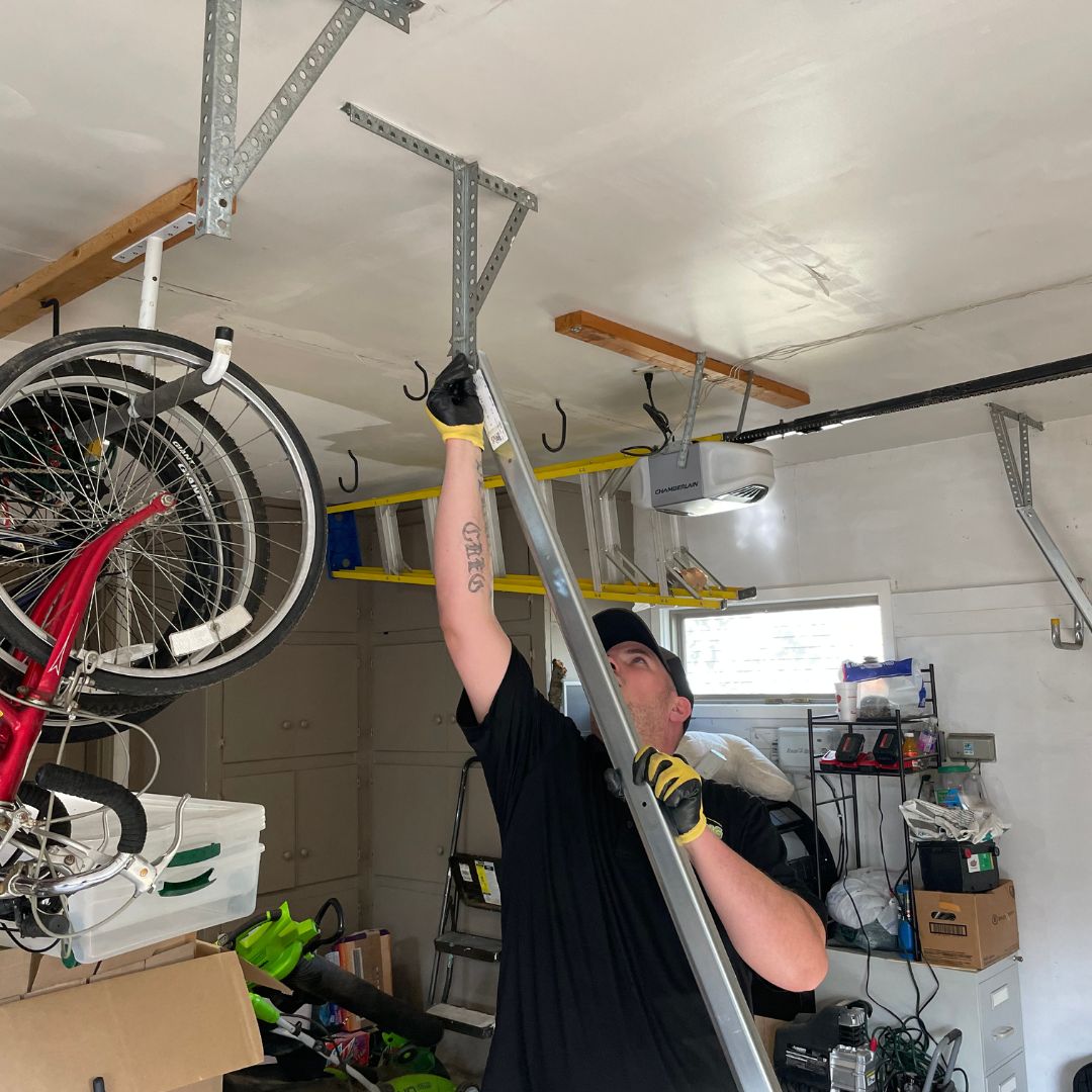 garage door repair technician adjusts a bracket overhead