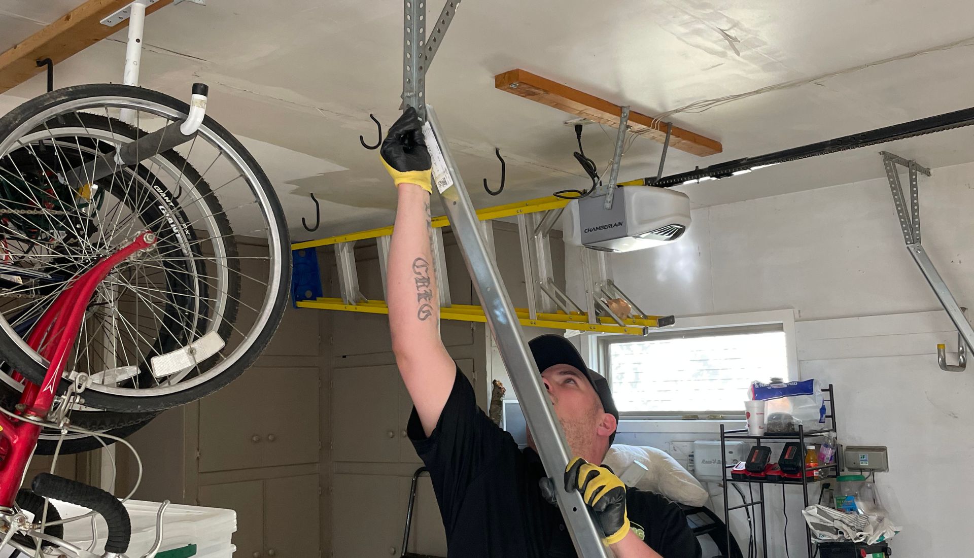 garage door repair technician adjusts a bracket overhead