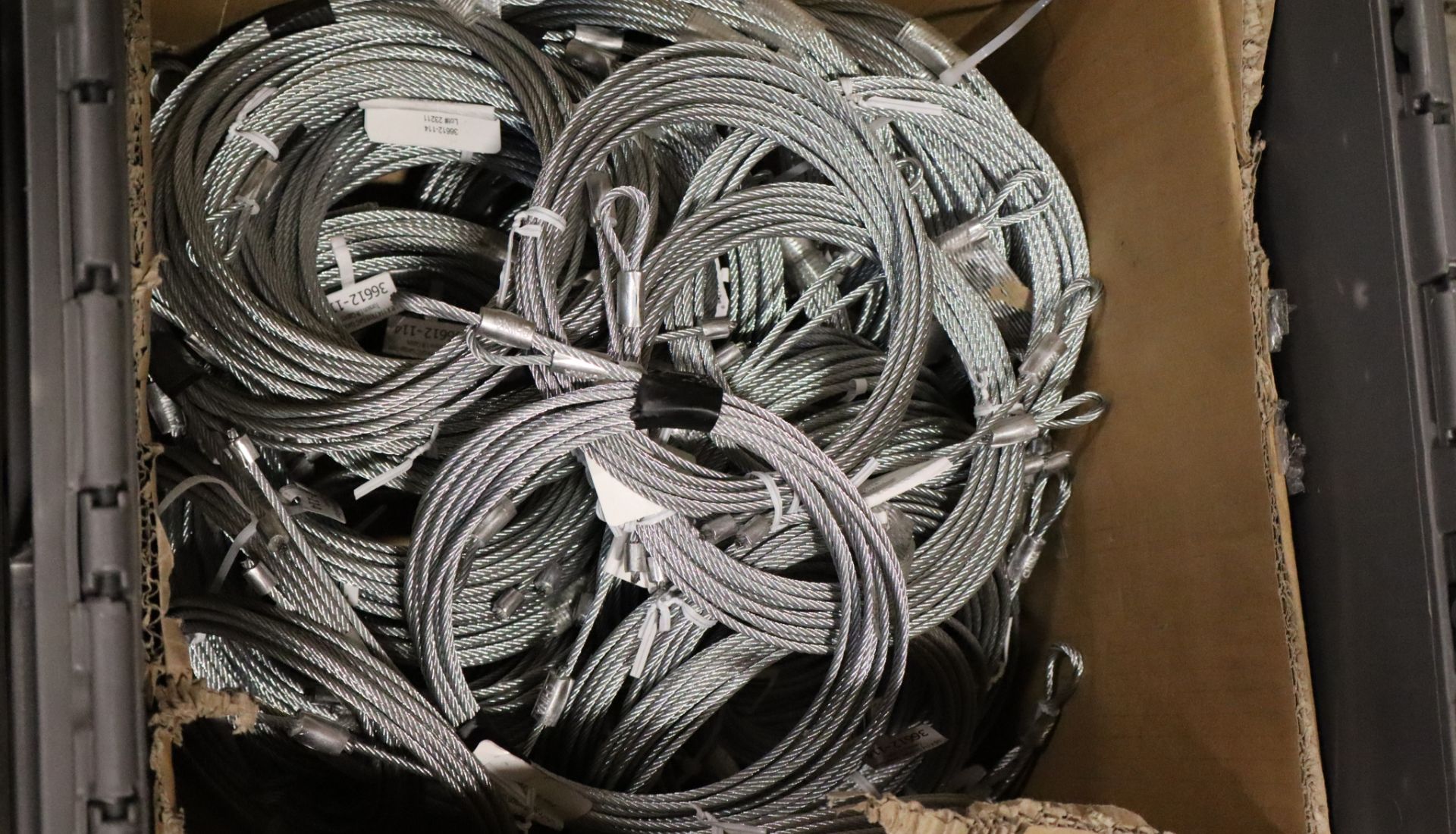 Many spools of garage door cable inside a box