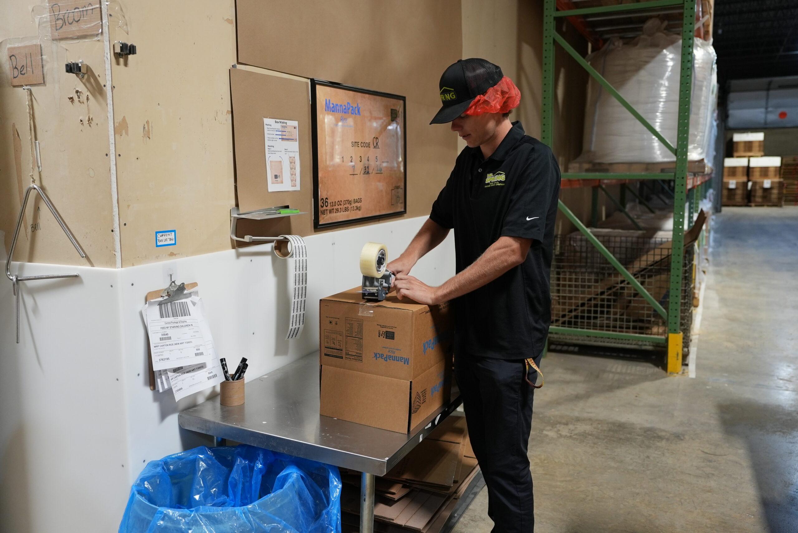 Tyler Kurr, General Manager of Mr. Spring Garage Doors, building and labeling boxes.